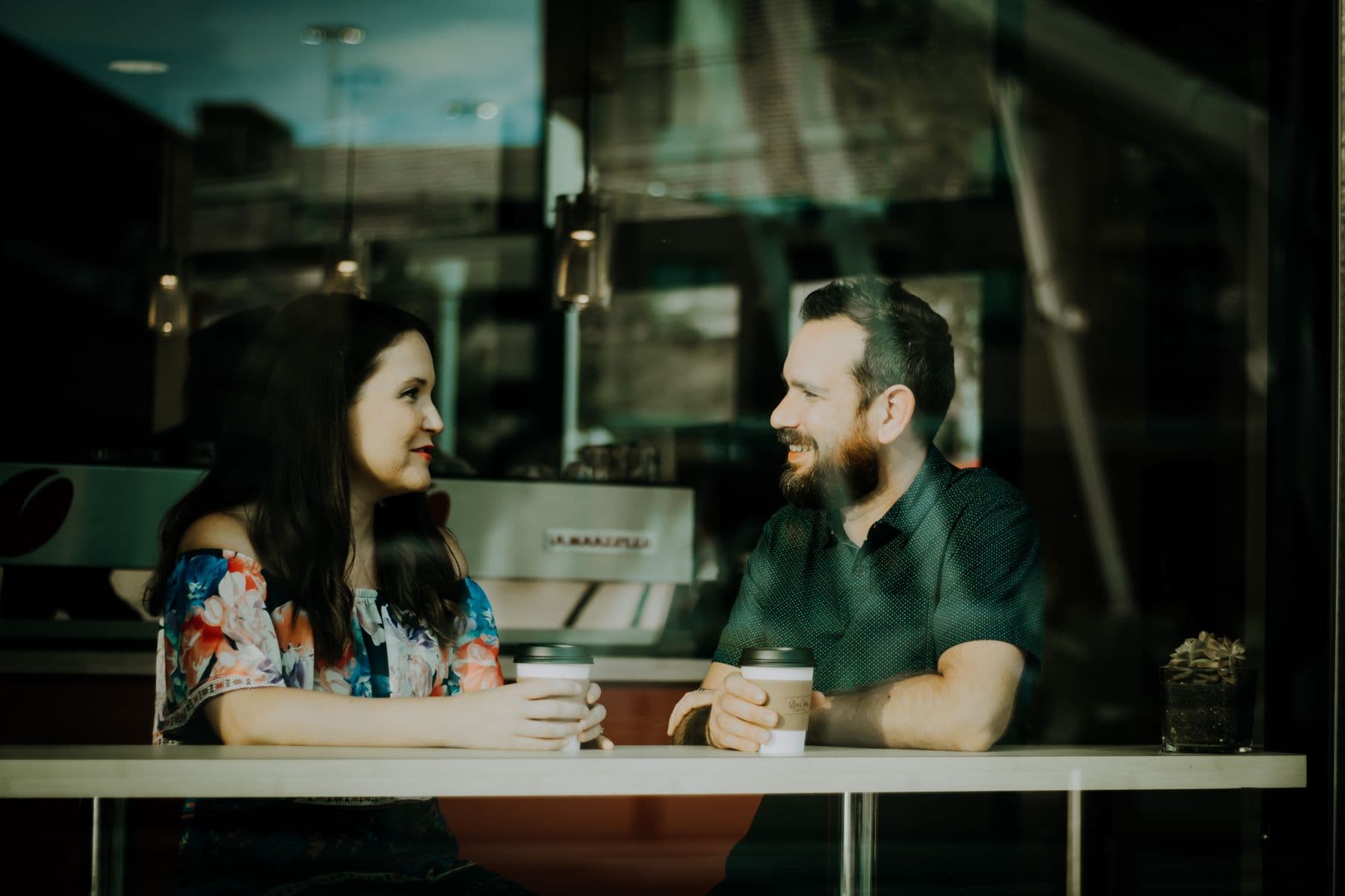 A couple talking and laughing over coffee, the kind of easy connection couples counseling helps restore