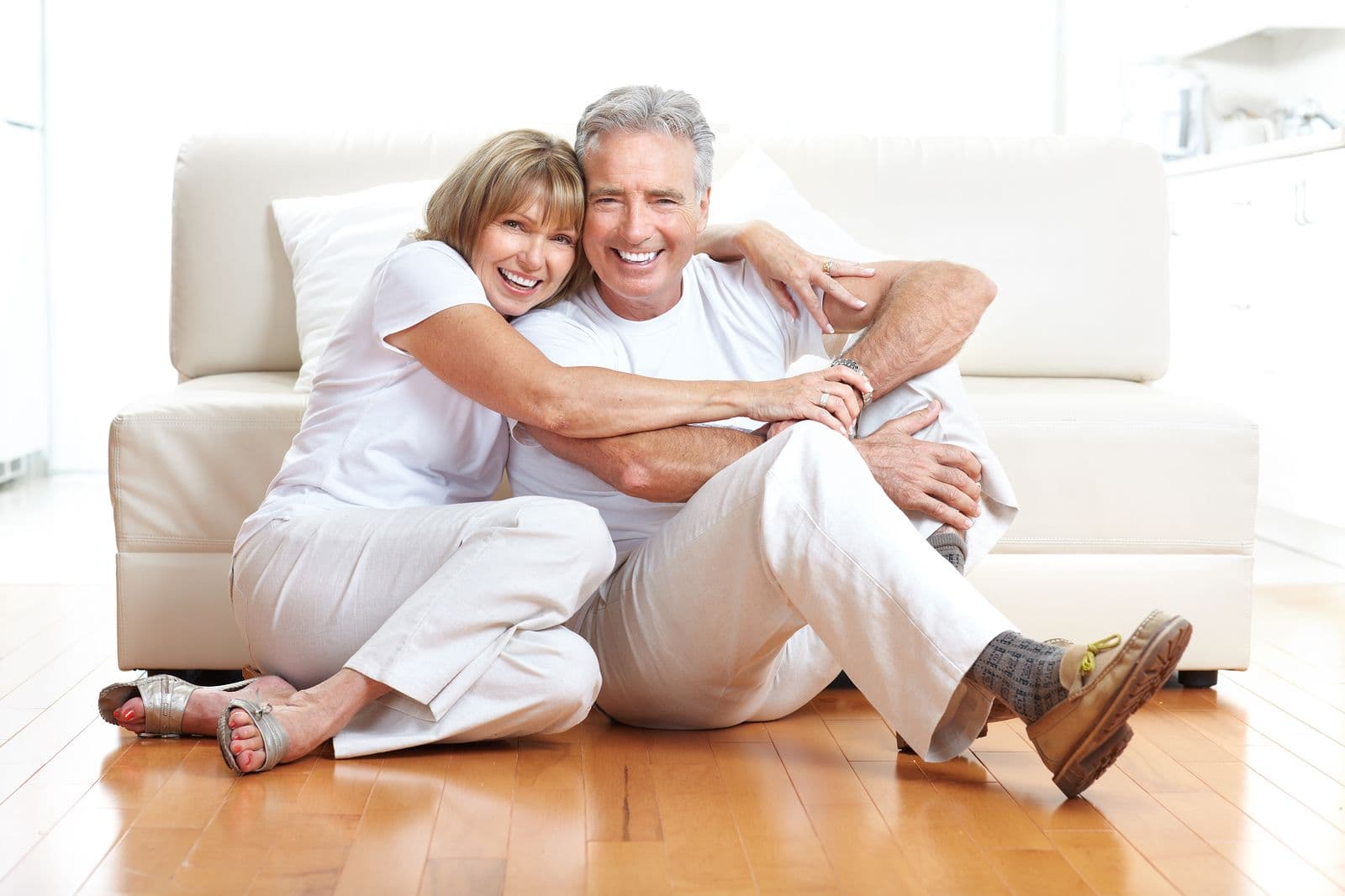 Older couple laughing together on their living room floor