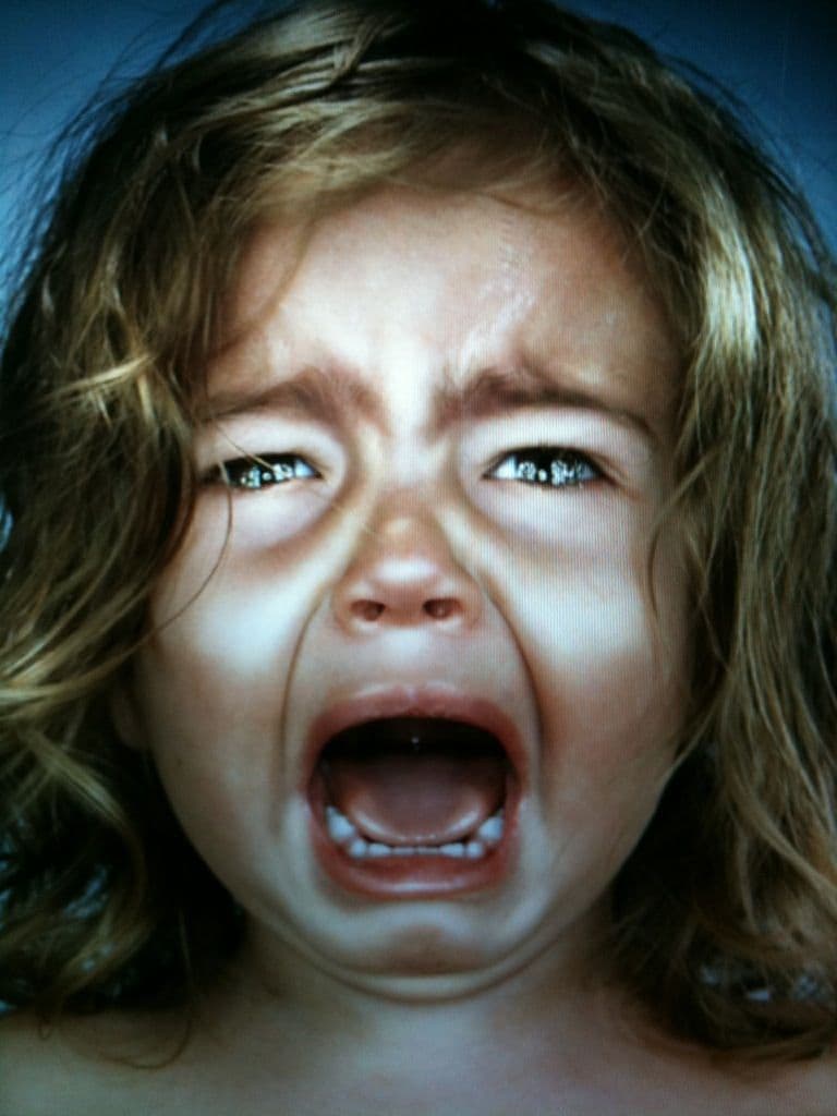 Young child having big feelings while a parent stays calm nearby