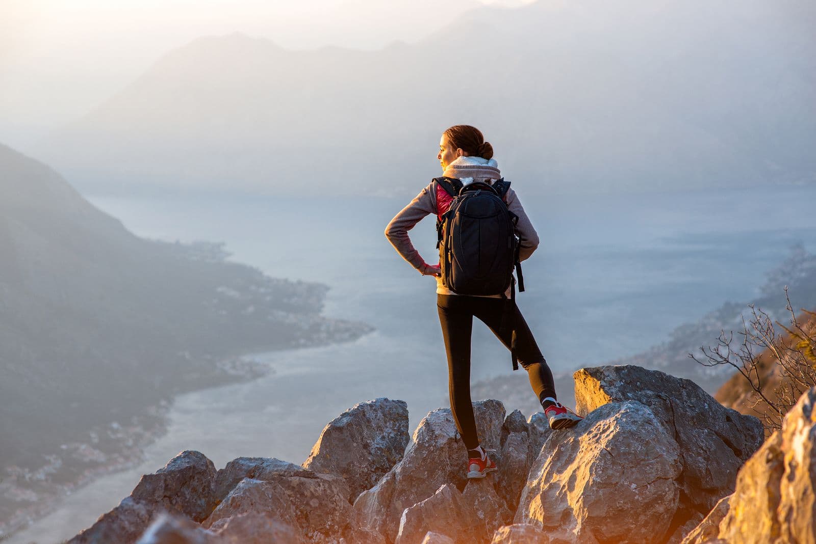 Person standing confidently on a mountain summit, symbolizing renewed self-worth